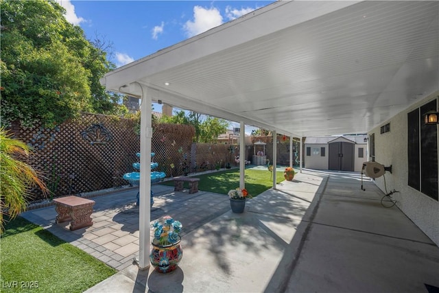 4644 Canna Dr, Las Vegas, NV 89122 - view of patio featuring a shed, a fenced backyard, and an outbuilding