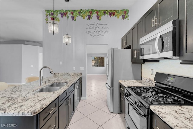 4644 Canna Dr, Las Vegas, NV 89122 - kitchen with appliances with stainless steel finishes, a sink, light tile patterned flooring, a peninsula, and light stone counters