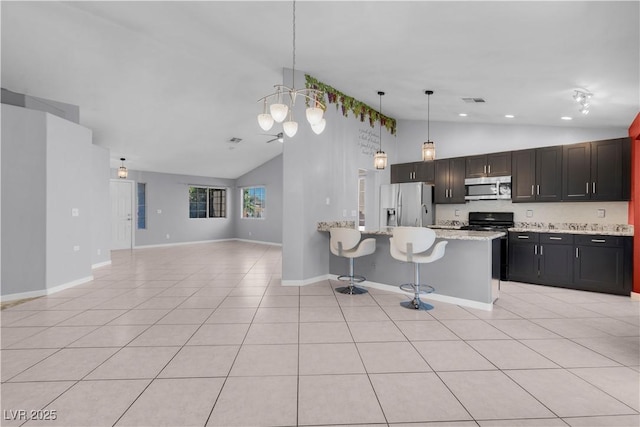 4644 Canna Dr, Las Vegas, NV 89122 - kitchen with appliances with stainless steel finishes, open floor plan, light tile patterned floors, a peninsula, and a kitchen bar