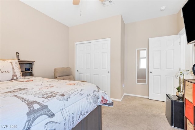 bedroom featuring light colored carpet, a closet, baseboards, and ceiling fan