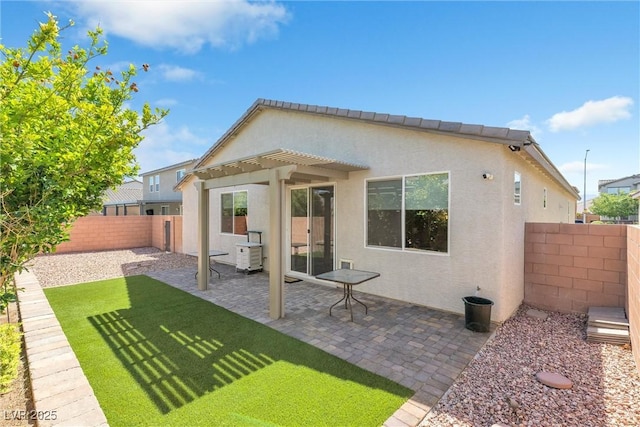 back of property with stucco siding and a patio