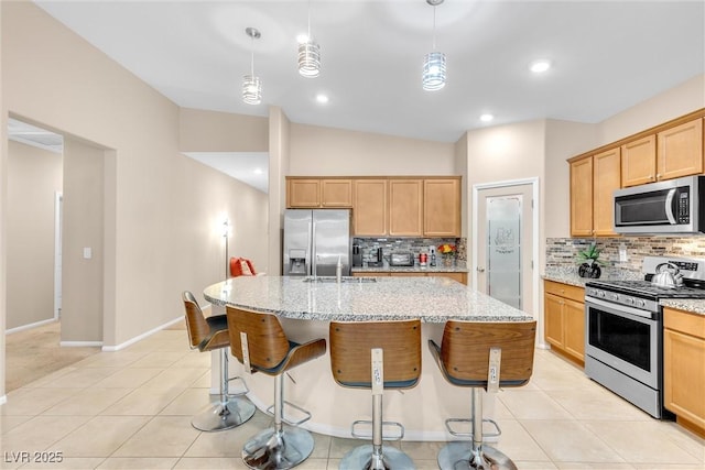 kitchen featuring appliances with stainless steel finishes, a sink, decorative backsplash, light stone countertops, and lofted ceiling