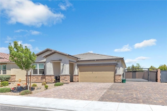 ranch-style house featuring decorative driveway, stone siding, a gate, a garage, and stucco siding