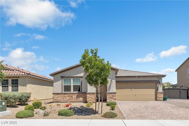 view of front of property featuring decorative driveway, stone siding, a garage, stucco siding, and fence
