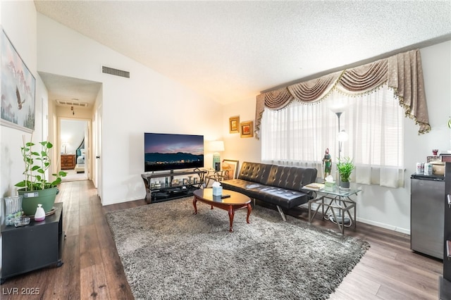 2261 Tall Pine Dr, Las Vegas, NV 89108 - living room featuring wood finished floors, lofted ceiling, and a textured ceiling