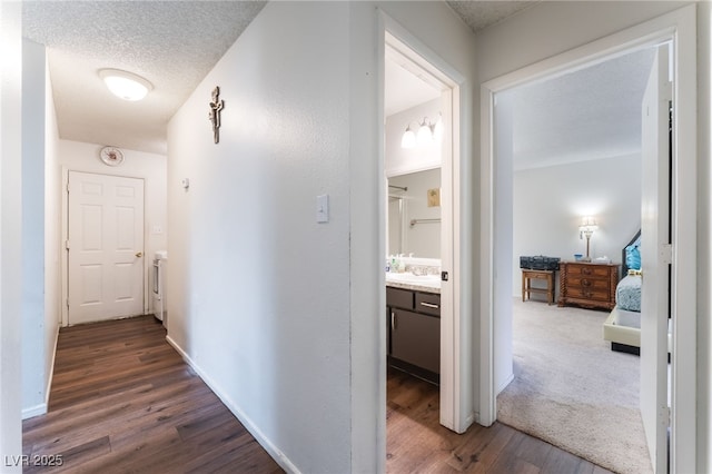 2261 Tall Pine Dr, Las Vegas, NV 89108 - hallway featuring dark wood-style flooring, baseboards, and a textured ceiling