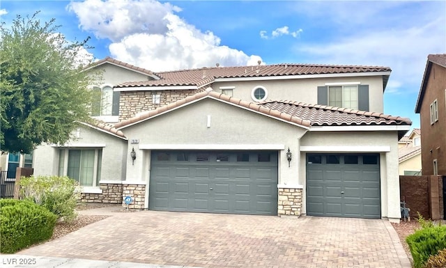 mediterranean / spanish-style house featuring stone siding, a garage, stucco siding, and decorative driveway