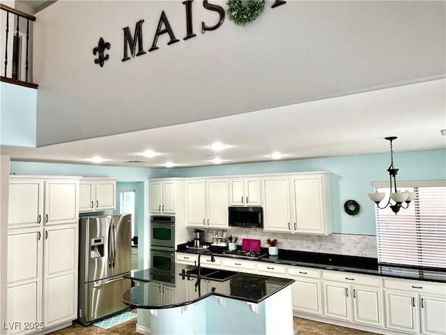 kitchen with stainless steel refrigerator with ice dispenser, double oven, a sink, stovetop, and decorative backsplash