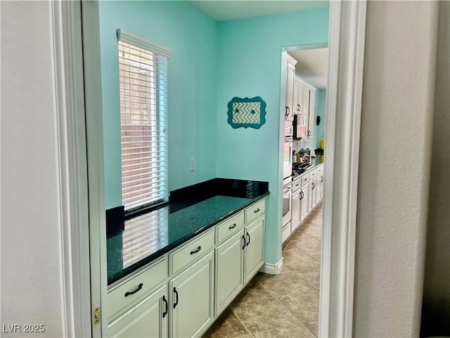 bar with light tile patterned flooring, stainless steel microwave, wall oven, and gas stovetop