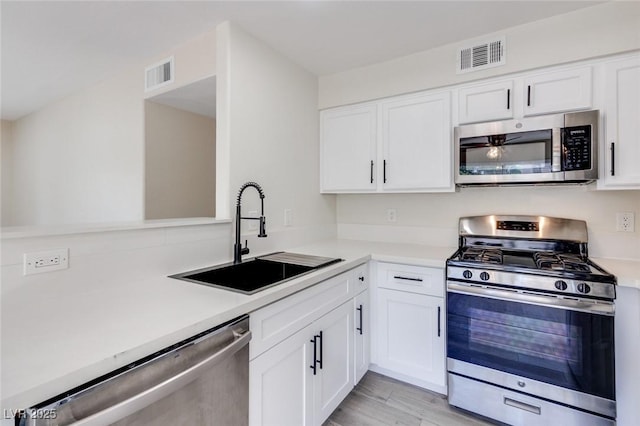 kitchen with stainless steel appliances, a sink, and light countertops