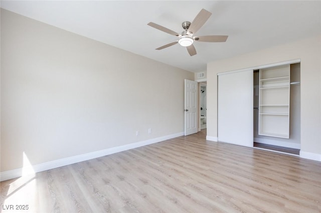 unfurnished bedroom with light wood-type flooring, a closet, baseboards, and a ceiling fan