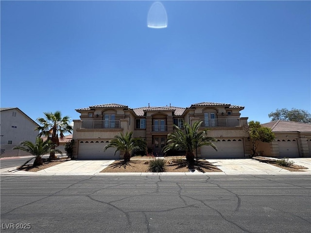 357 Whispering Tree Ave, Las Vegas, NV 89183 - mediterranean / spanish-style home with a balcony, an attached garage, and stucco siding