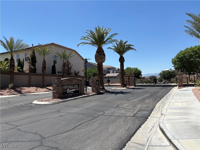 357 Whispering Tree Ave, Las Vegas, NV 89183 - view of asphalt street featuring sidewalks, curbs, a gated entry, and a gate