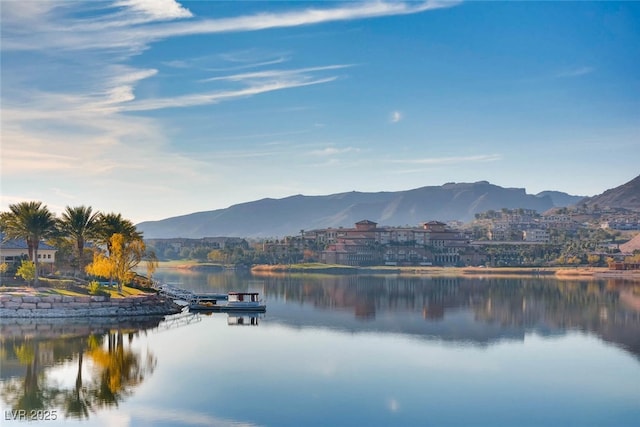 water view featuring a mountainous background and a boat dock