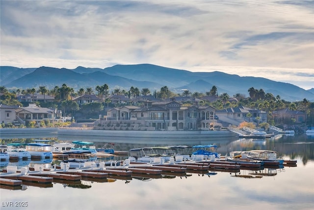 view of mountain backdrop featuring a nearby body of water and nearby suburban area
