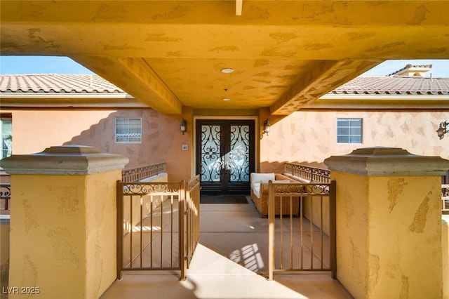 property entrance featuring a gate, stucco siding, and a tile roof