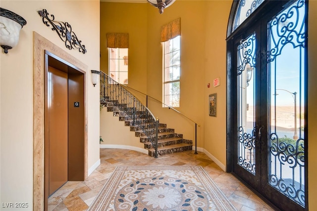 entryway with french doors, plenty of natural light, stairway, and baseboards