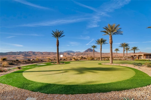 view of home's community featuring a mountain view and a putting green