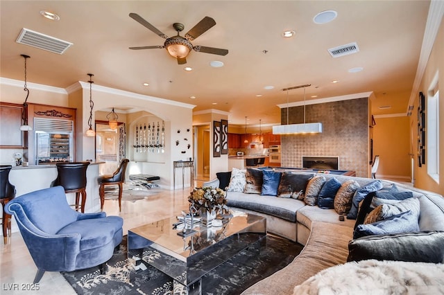 living area featuring ceiling fan, recessed lighting, and crown molding