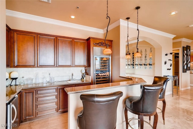 kitchen with wine cooler, crown molding, a sink, light stone countertops, and a breakfast bar