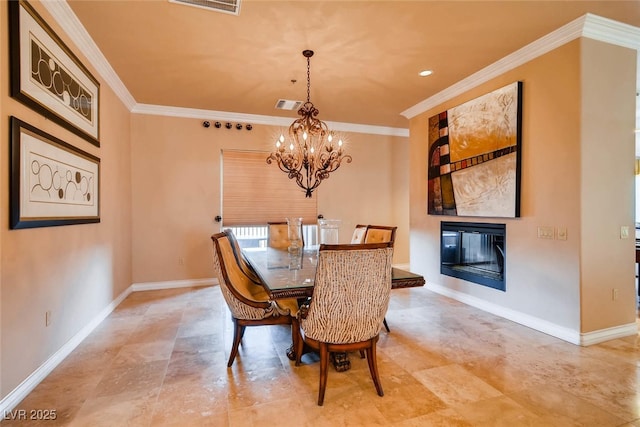 dining room with ornamental molding, a chandelier, baseboards, a glass covered fireplace, and recessed lighting