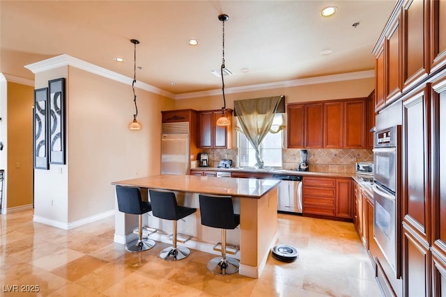 kitchen with appliances with stainless steel finishes, a kitchen island, brown cabinets, tasteful backsplash, and a breakfast bar area