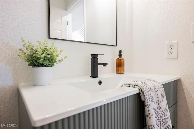 bathroom featuring vanity and a textured wall