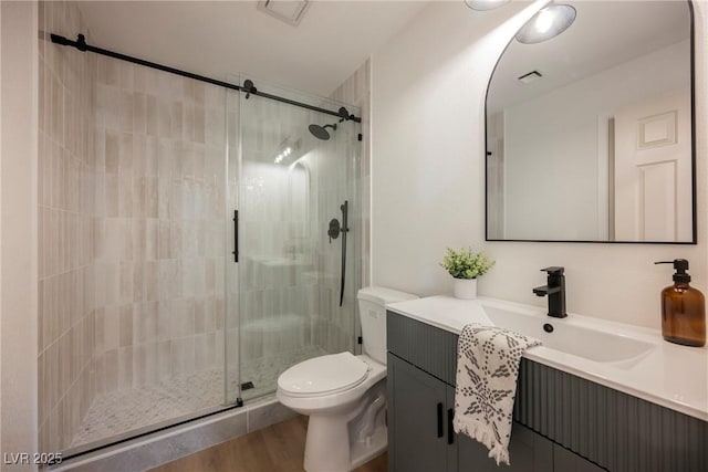 full bathroom with toilet, a shower stall, vanity, and wood finished floors