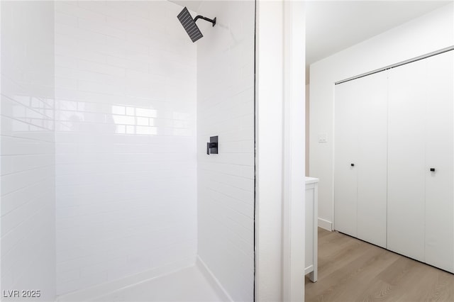 bathroom featuring a tile shower and wood finished floors