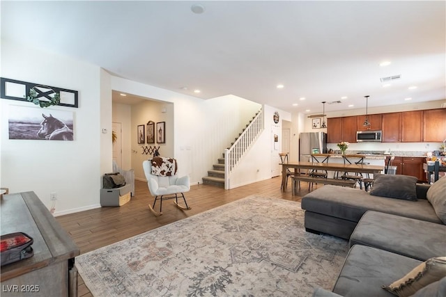 living room with stairs, wood finished floors, recessed lighting, and baseboards