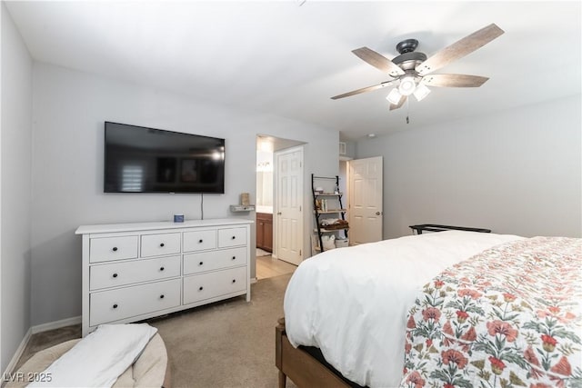 bedroom featuring light carpet, ensuite bath, and a ceiling fan