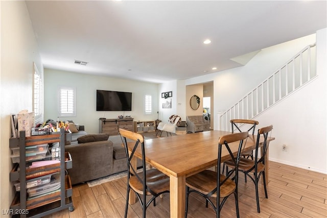 dining room featuring light wood-type flooring, stairway, and recessed lighting