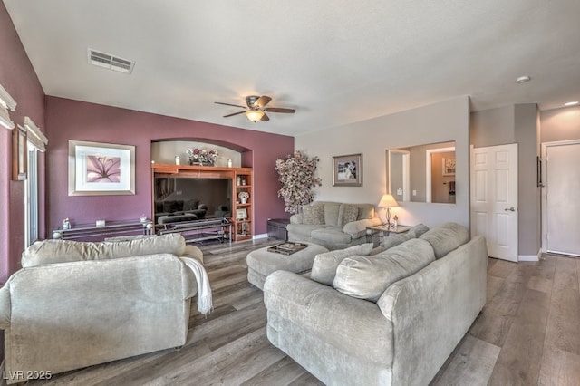 living area featuring ceiling fan, wood finished floors, and baseboards