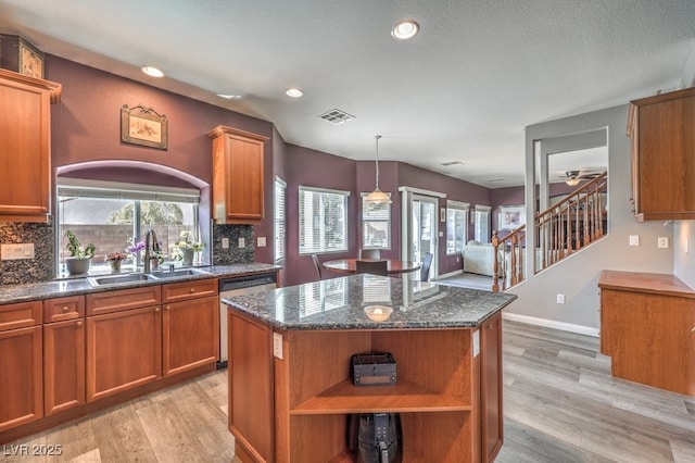 kitchen with open shelves, a sink, stainless steel dishwasher, light wood-type flooring, and decorative backsplash