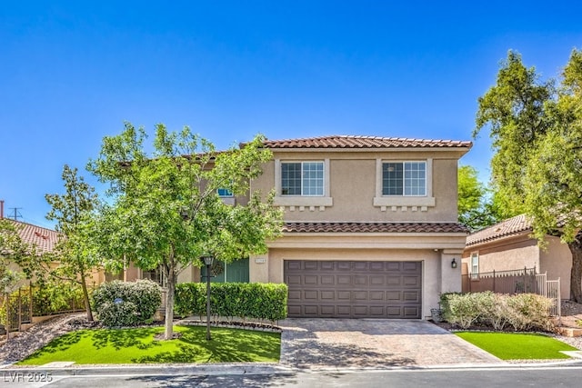 view of front of home with a tile roof, a garage, stucco siding, and driveway