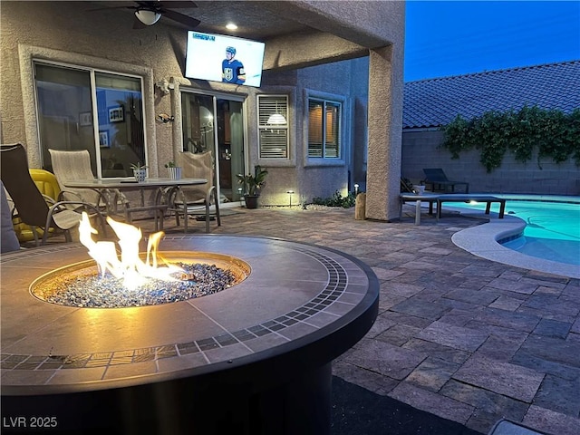 view of patio with a fire pit, a ceiling fan, and fence