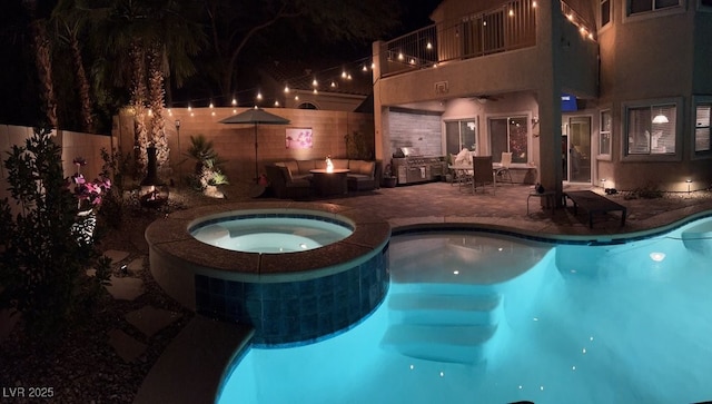 pool at twilight with a patio area, a pool with connected hot tub, and fence