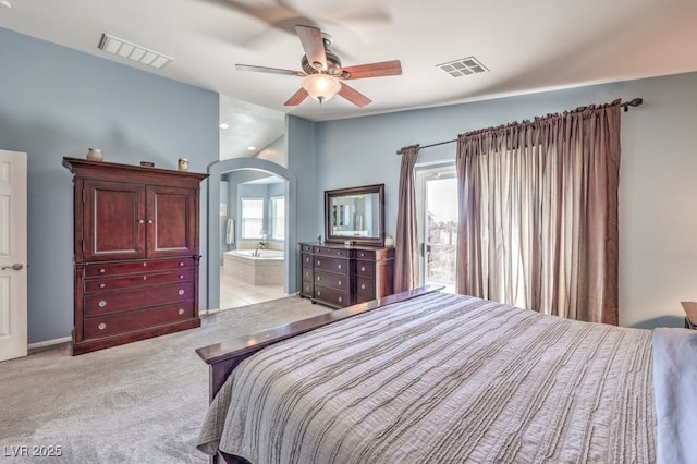 bedroom featuring arched walkways, light colored carpet, ceiling fan, and connected bathroom