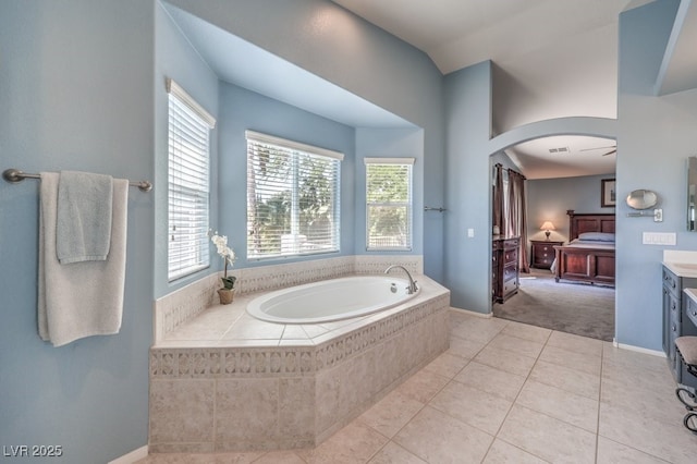 ensuite bathroom with a bath, tile patterned floors, vanity, and baseboards