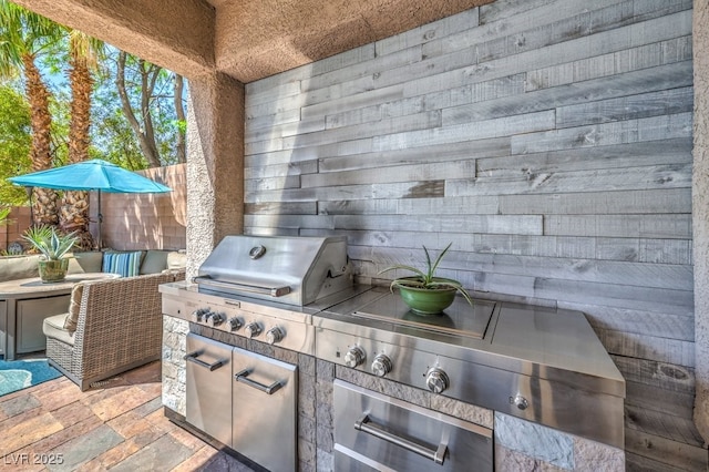 view of patio featuring an outdoor kitchen, fence, and grilling area
