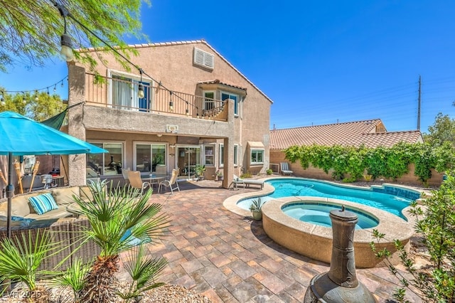 view of swimming pool with a patio, a pool with connected hot tub, and a fenced backyard