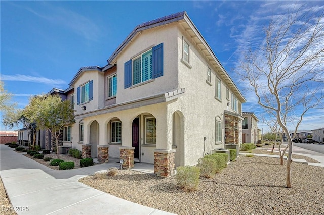 8562 Insignia Ave Unit 102, Las Vegas, NV 89178 - view of front of property featuring stucco siding, central AC, stone siding, and covered porch