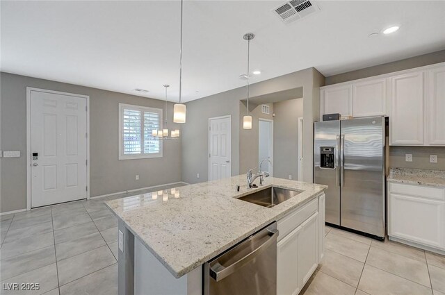 8562 Insignia Ave Unit 102, Las Vegas, NV 89178 - kitchen with stainless steel appliances, a sink, light tile patterned floors, white cabinetry, and a center island with sink