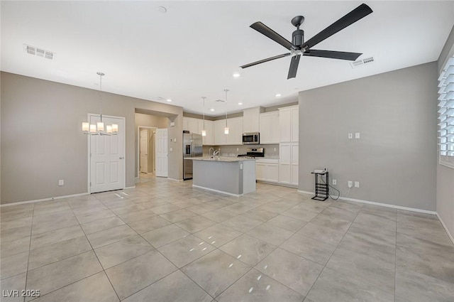 8562 Insignia Ave Unit 102, Las Vegas, NV 89178 - kitchen featuring stainless steel appliances, a ceiling fan, light countertops, white cabinets, and a center island with sink