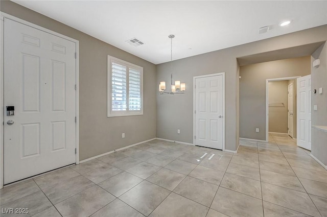 8562 Insignia Ave Unit 102, Las Vegas, NV 89178 - unfurnished dining area featuring a chandelier, light tile patterned floors, and baseboards