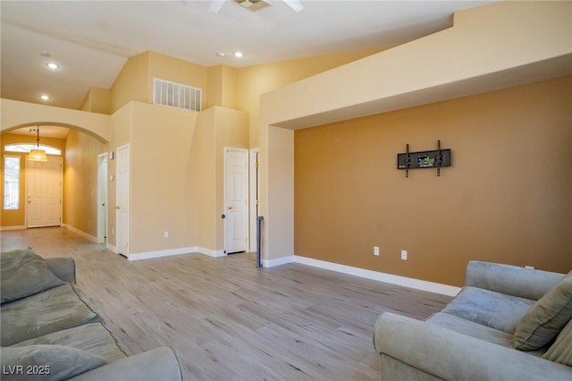 9710 Geiger Peak Ct, Las Vegas, NV 89148 - living area featuring arched walkways, light wood-style floors, baseboards, recessed lighting, and high vaulted ceiling