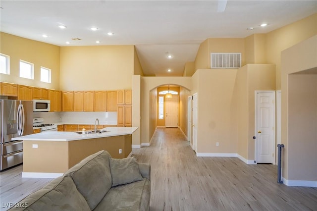 9710 Geiger Peak Ct, Las Vegas, NV 89148 - kitchen with white appliances, a sink, a high ceiling, open floor plan, and arched walkways