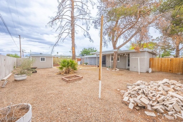 fenced backyard with an outdoor structure and a storage shed
