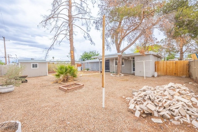 fenced backyard featuring an outdoor structure and a storage unit