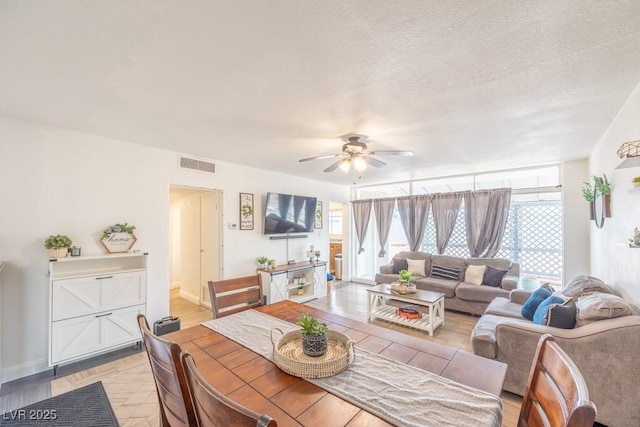 dining room featuring ceiling fan, healthy amount of natural light, baseboards, and a textured ceiling
